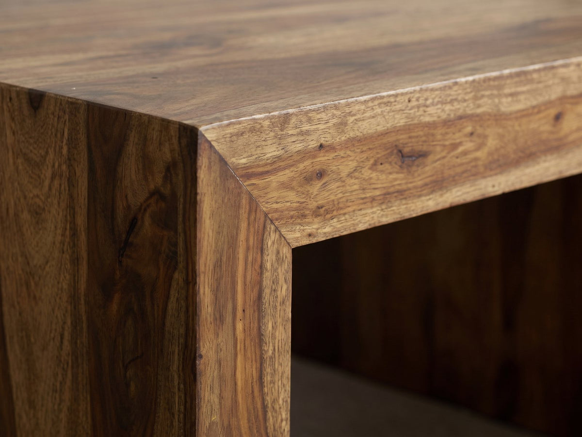 Close-up of the Chieri 34-Inch Square Solid Sheesham Waterfall Coffee Table: the mitred corner where the thick sheesham top meets an end panel