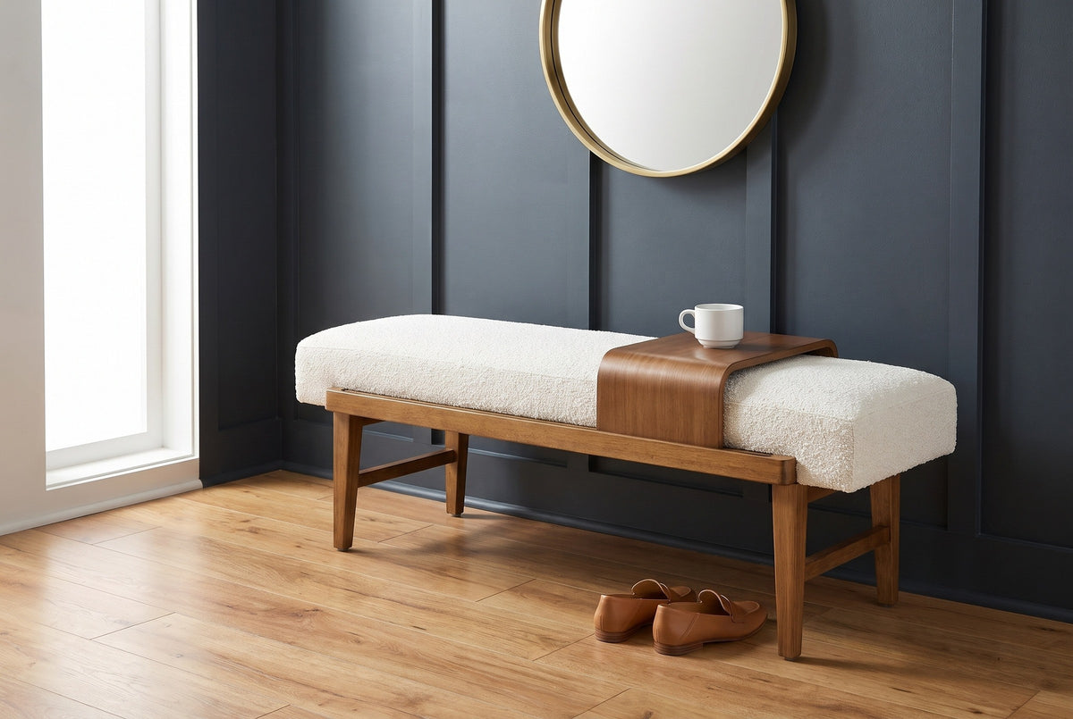 Citerna bench against a charcoal-blue panelled wall in a Nashville entry hall with a round brass mirror above, a white cup on the tray and a pair of loafers on the floor