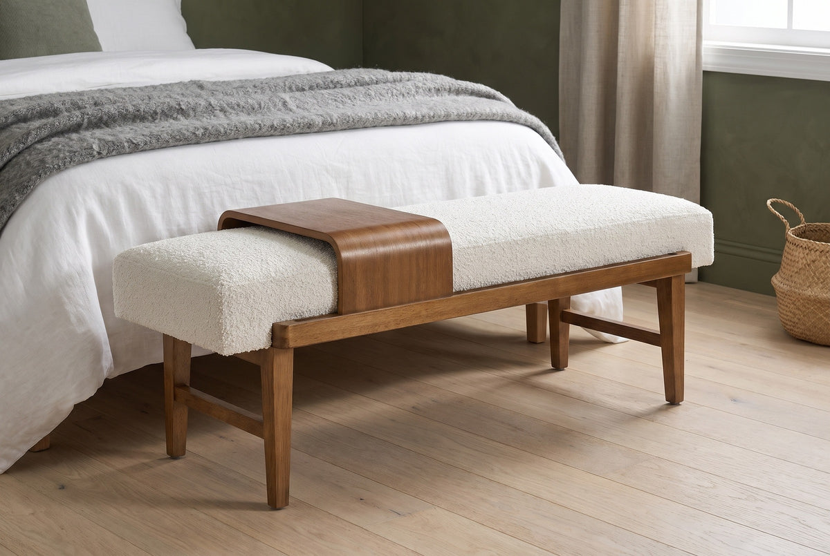 Citerna bench at the foot of a bed with white linen and a grey wool throw in a Portland bedroom with a deep olive-green limewash wall and pale oak floor, a seagrass basket beside it