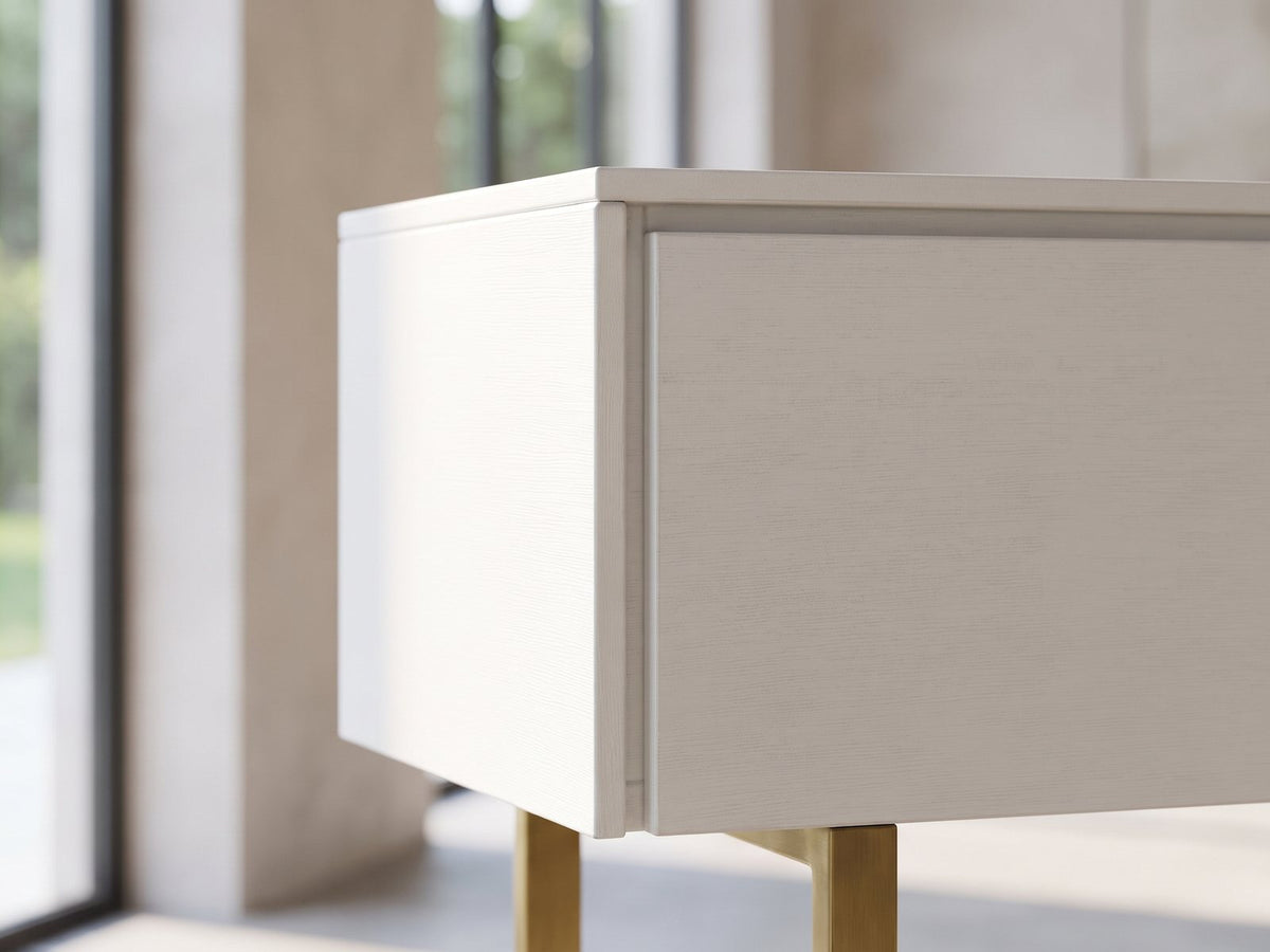 Close-up of the Cittadella White Media Console: the top corner of the white console with its subtle wood grain and the brass leg below