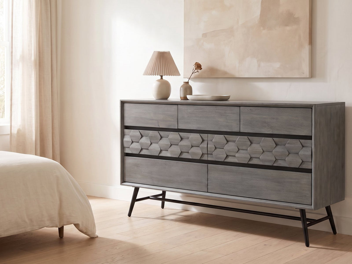 Codroipo 61-Inch Gray Acacia Honeycomb Dresser against a plaster wall under an abstract canvas in a bright bedroom