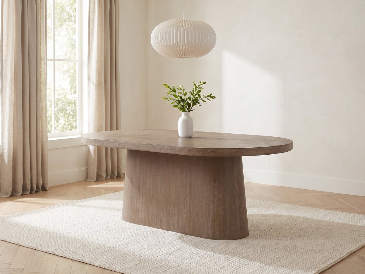 Cotronei 84-Inch Oval Cocoa Wood Veneer Pedestal Dining Table in a bright plaster dining room with linen curtains