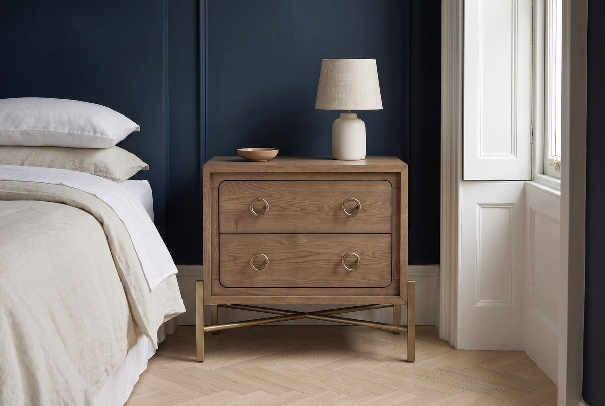 Cuglieri latte elm nightstand against a deep navy wall in a Brooklyn brownstone bedroom with a herringbone floor and a white shuttered window