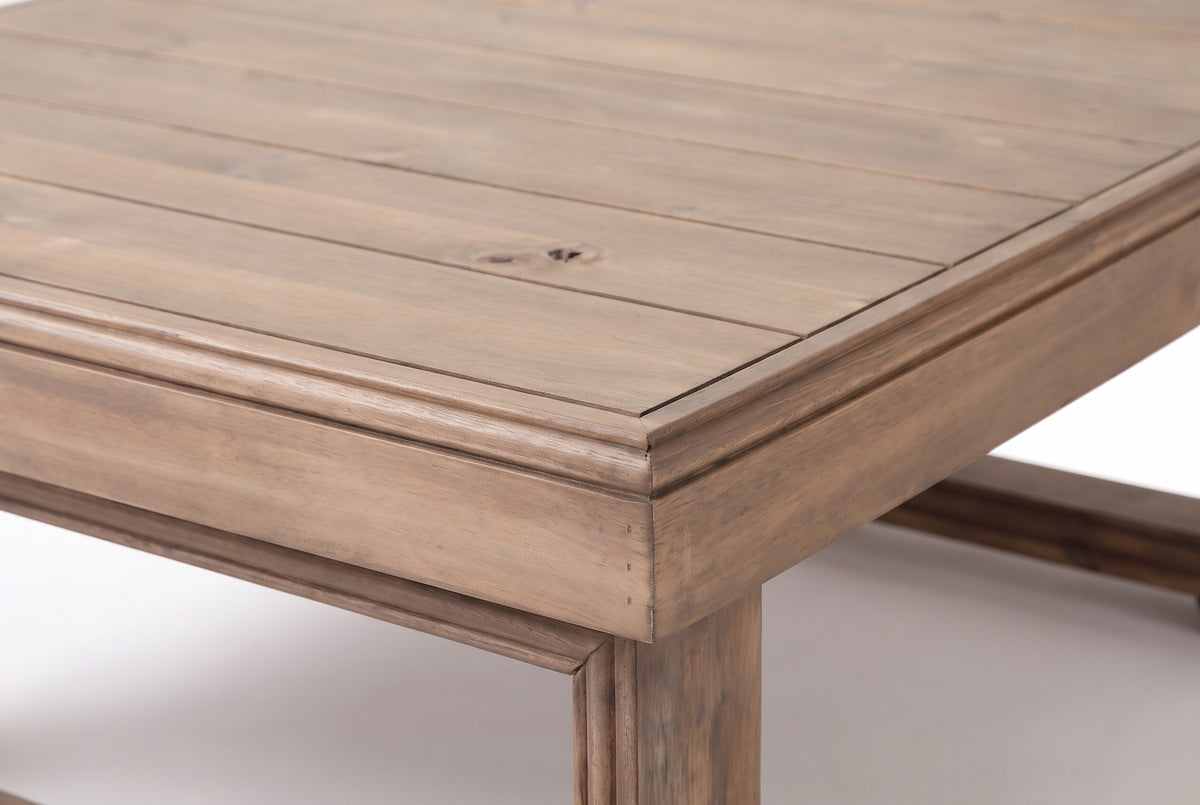 Close-up of the Custonaci table: acacia planks with natural grain and a knot, the border frame and the moulded apron corner