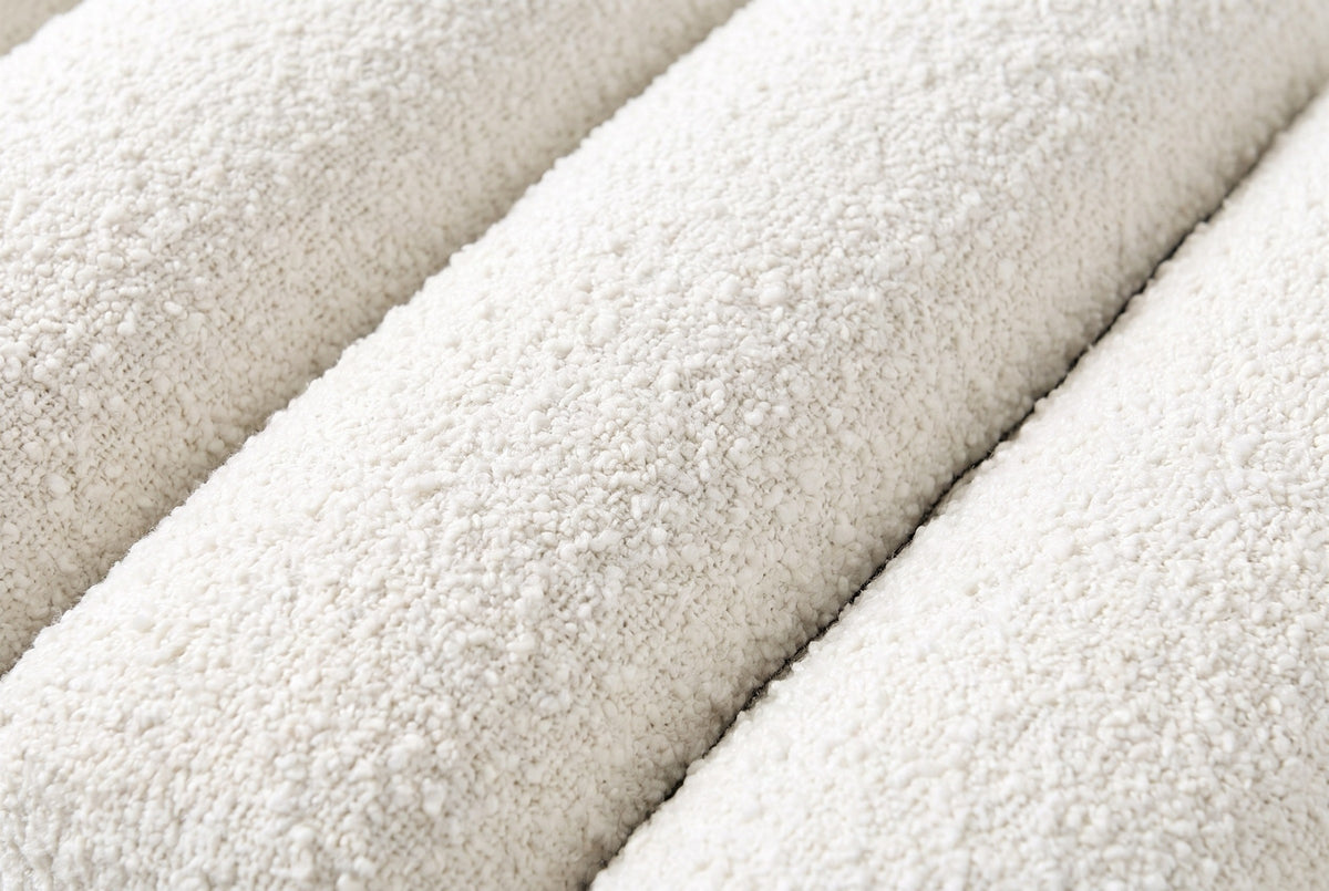 Close-up of the ivory white boucle on the Deruta bench: a nubby looped texture across three rounded channels