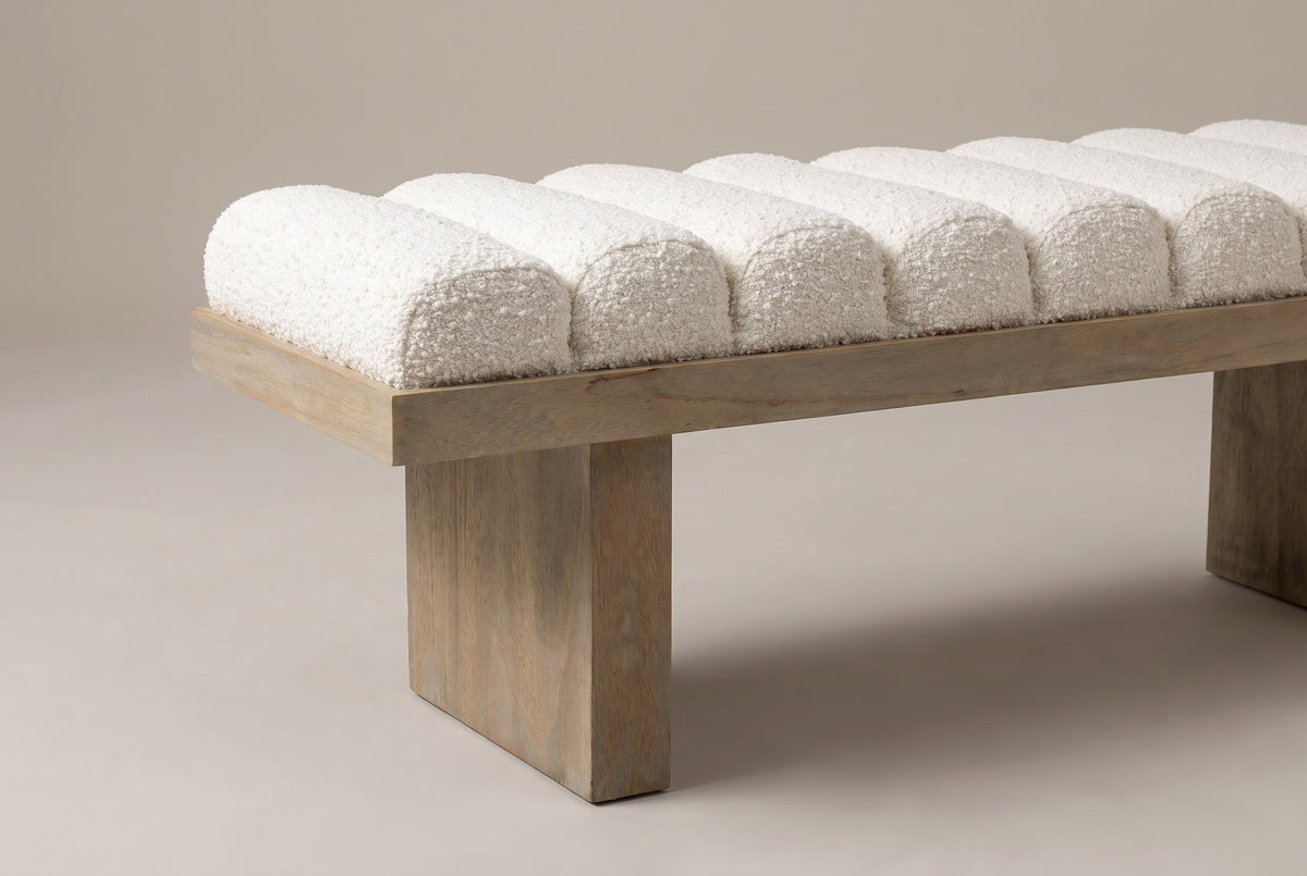 One end of the Deruta bench: the row of rounded, domed boucle channels sitting in the flat wire-brushed wood frame, above a thick slab leg