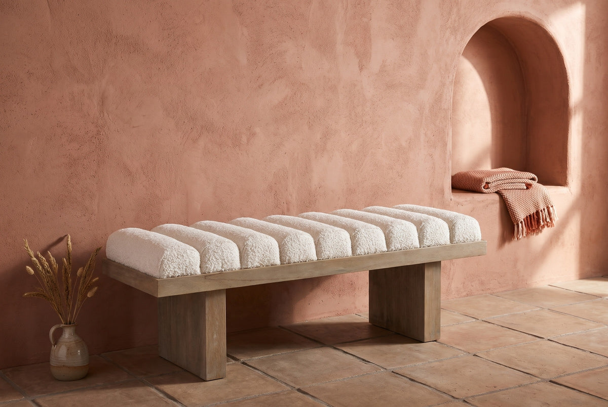 Deruta bench against a terracotta clay-plaster wall in a Santa Fe entry hall, with an arched niche, a clay tile floor and a vase of dried grasses