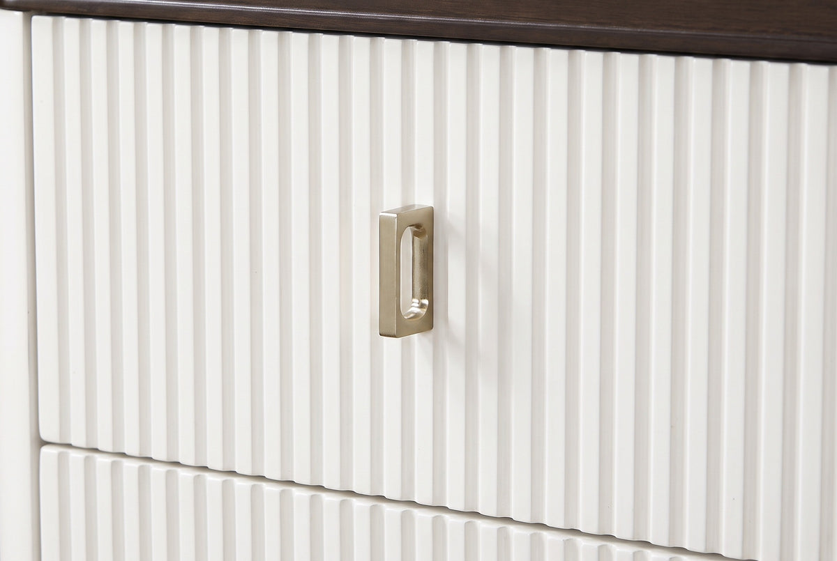 A fluted white drawer front of the Desulo nightstand with its small upright brass-finish pull