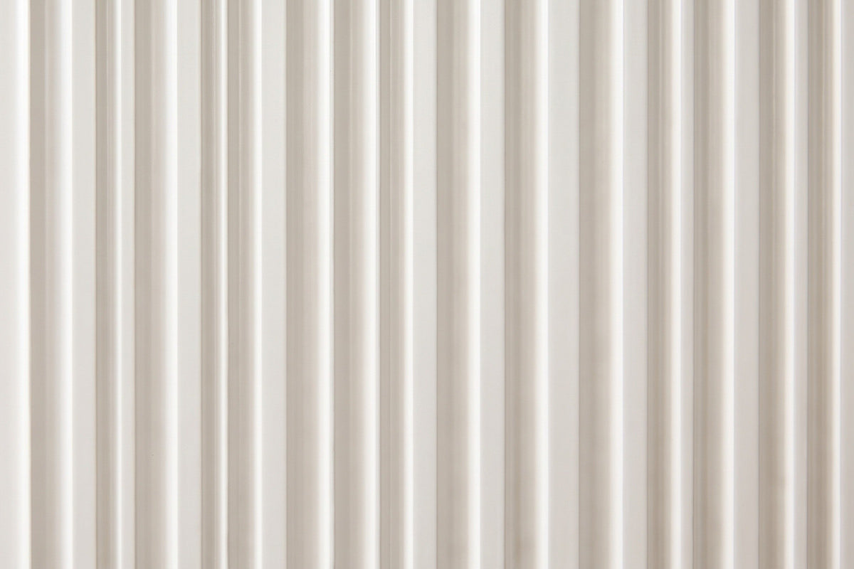 Close-up of the fine vertical flutes on a white drawer front of the Desulo nightstand