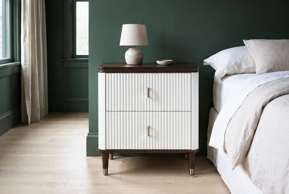 Desulo white fluted nightstand against a deep forest-green wall in a Portland bedroom with pale oak floorboards and linen curtains