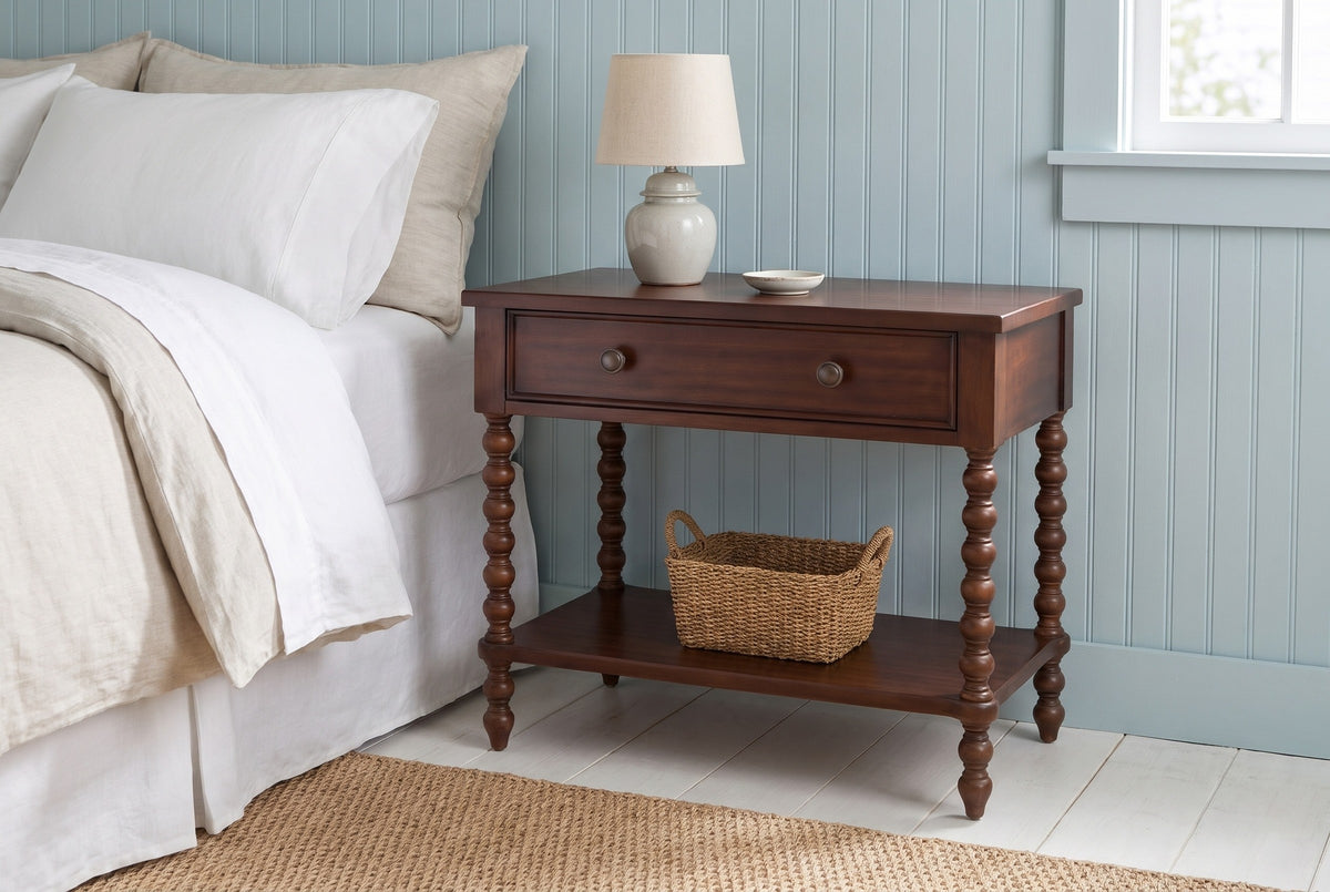 Dorgali Morocco Brown nightstand with a ceramic lamp and a seagrass basket against duck-egg blue beadboard in a Nantucket bedroom with a whitewashed plank floor and a seagrass rug