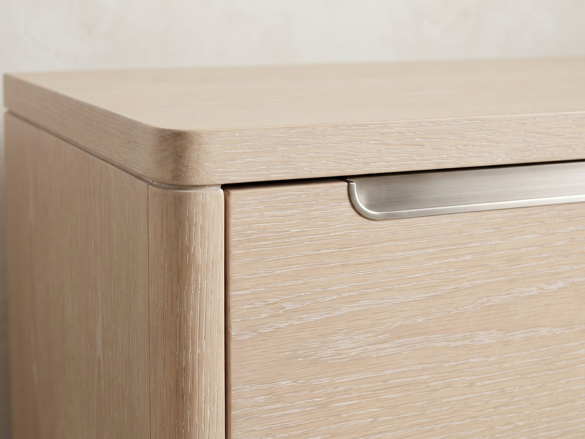 Close-up of the Este 66-Inch Light Elm 6-Drawer Dresser: the recessed brushed-nickel finger-pull slot along the top of a row of drawers
