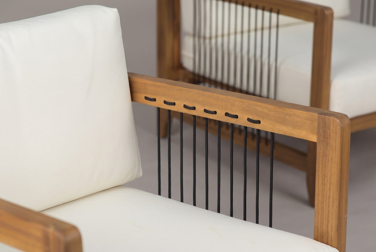 Close-up of a Ficarra armchair: the acacia arm rail in a natural teak finish with black rope looping through it, beside the ivory back cushion