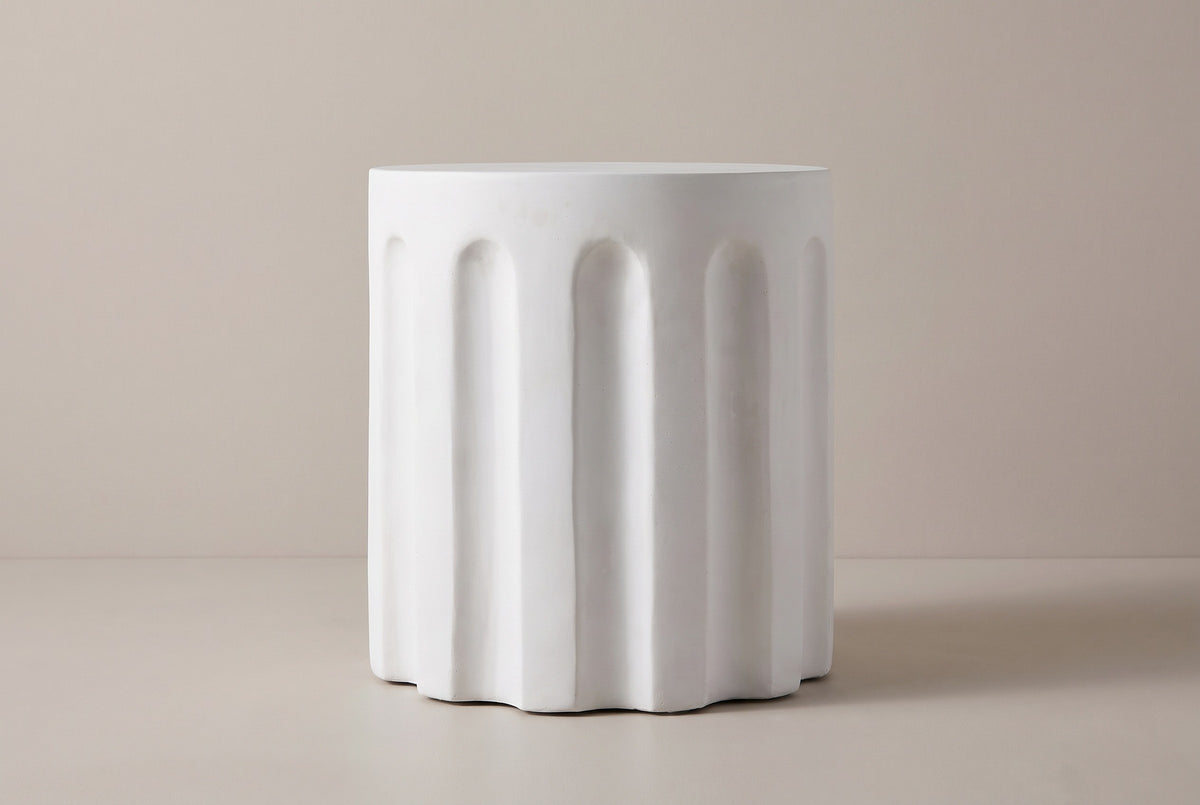 The Ficuzza side table seen straight from the side: a white cylinder with a plain top band and evenly spaced vertical flutes