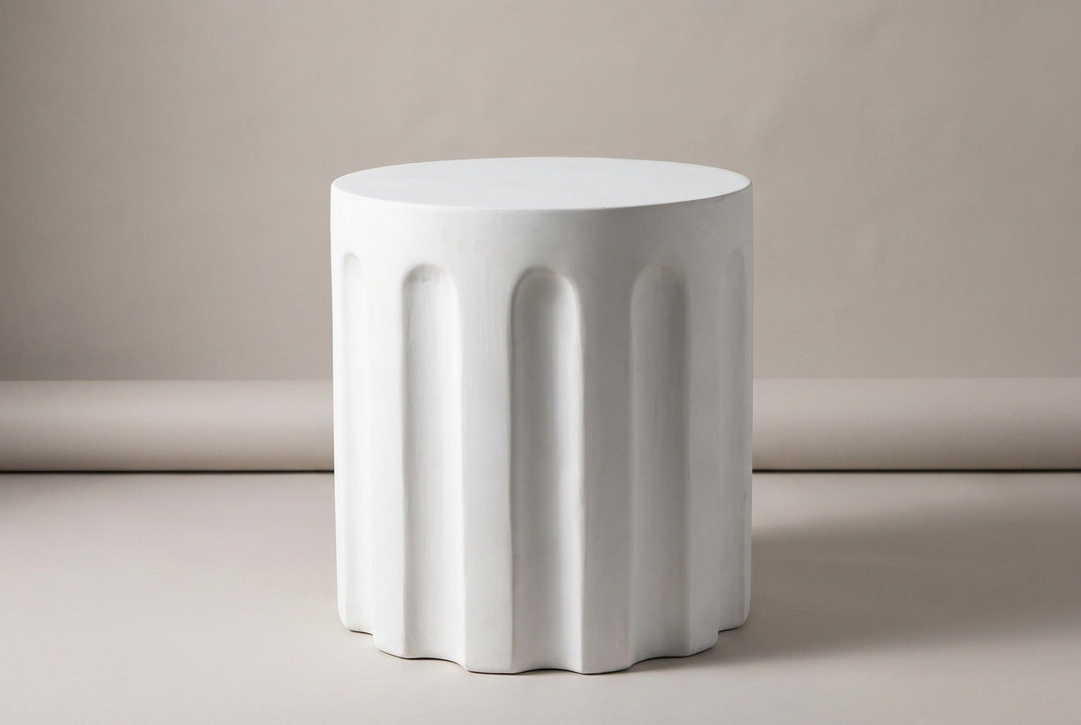 The Ficuzza white fluted concrete cylinder side table, three-quarter view on a light studio backdrop