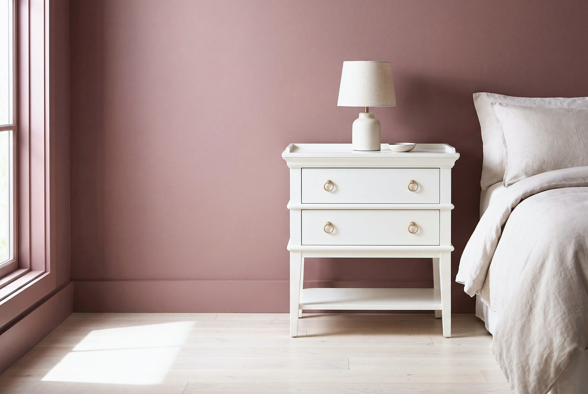 Fonni white tray-top nightstand with a ceramic lamp beside a bed in a Nashville bedroom with a dusty rose wall and a tall window