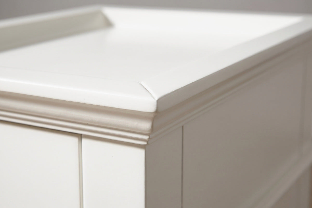 Close-up of the raised lip and the stepped cove moulding at the corner of the white tray top of the Fonni nightstand