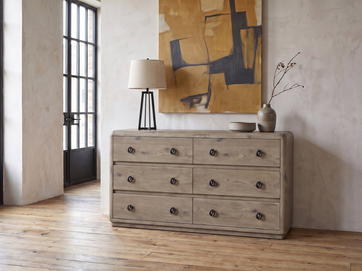 Fonzaso 66-Inch Weathered Knotty Oak 6-Drawer Dresser against a plaster wall in an industrial loft bedroom