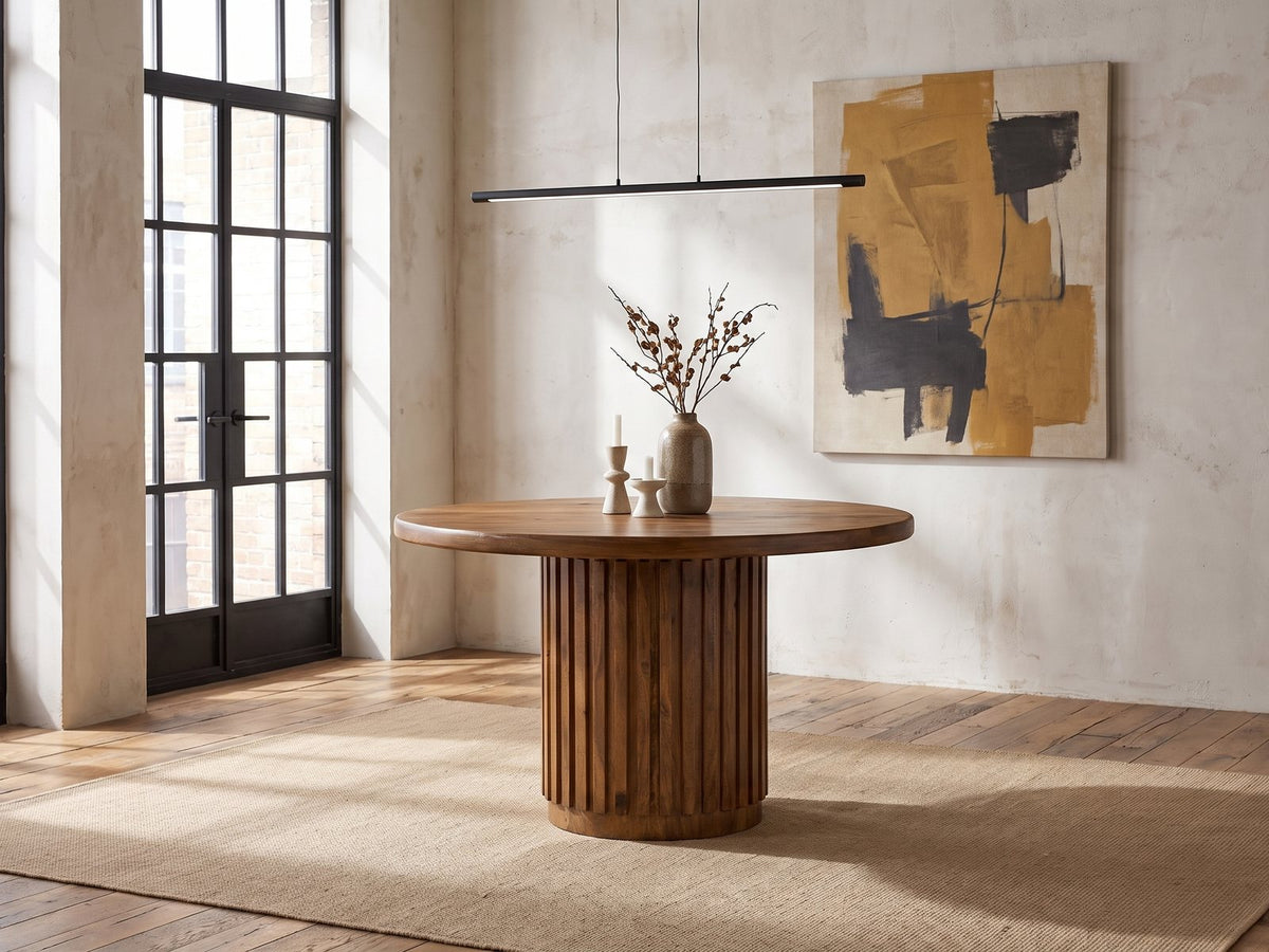 Fuscaldo 47-Inch Round Mango Wood Slatted Pedestal Dining Table in an industrial loft dining area