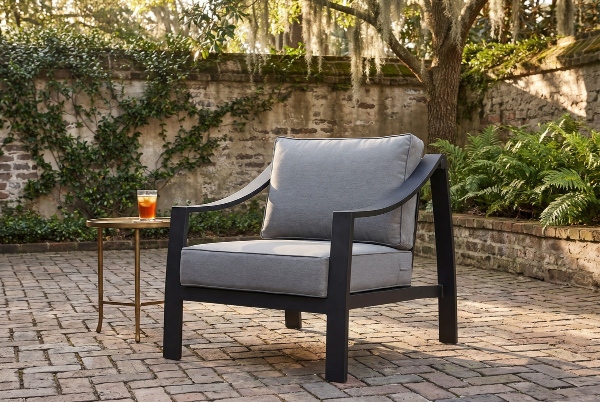 Galati black aluminum lounge chair on old brick pavers in a walled Savannah courtyard, ivy, ferns and a live oak with Spanish moss behind (side table not included)