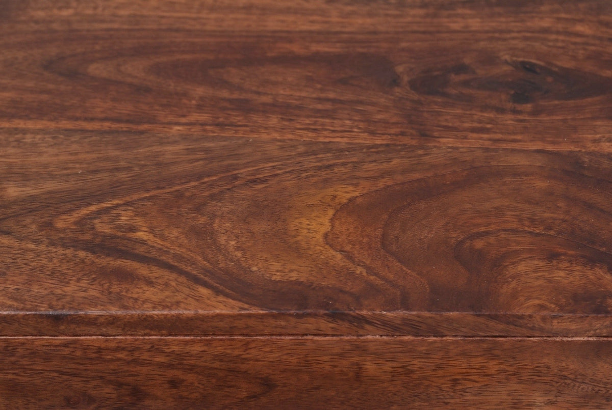 Close-up of the chestnut mango wood on the Galtelli nightstand: deep reddish brown swirling grain with amber patches running to a rounded edge