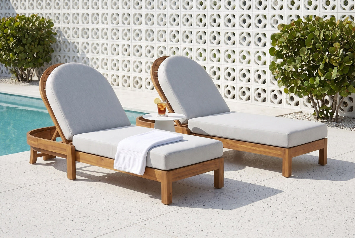 Two Gangi acacia chaise lounges on a terrazzo pool deck in Sarasota, a white breeze-block screen wall and sea grape behind (side table and towel not included)