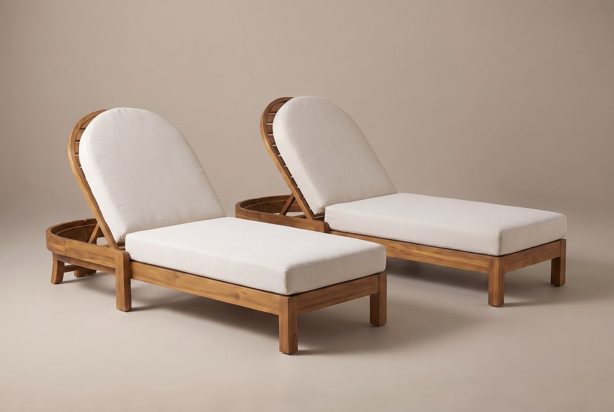 The two Gangi acacia chaise lounges with beige cushions and raised arched backrests, three-quarter view on a light studio backdrop