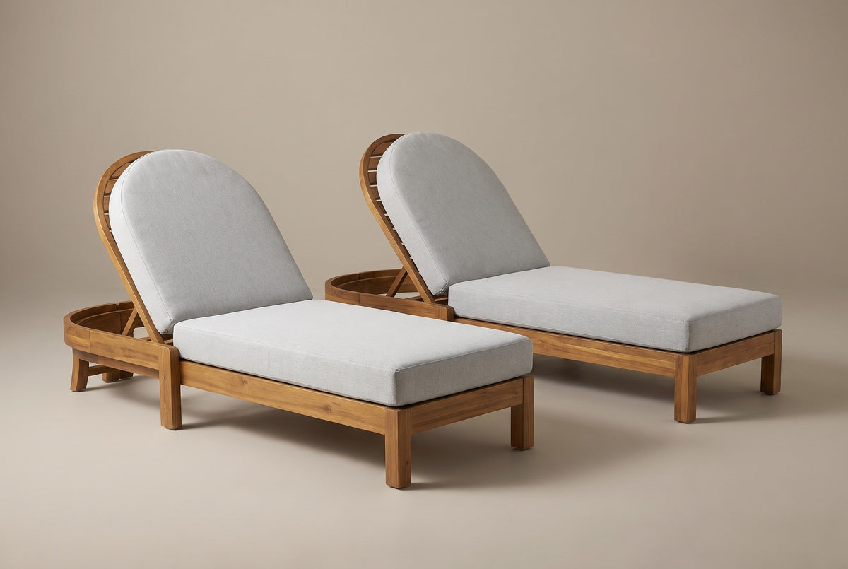 The two Gangi acacia chaise lounges with light grey cushions and raised arched backrests, three-quarter view on a light studio backdrop