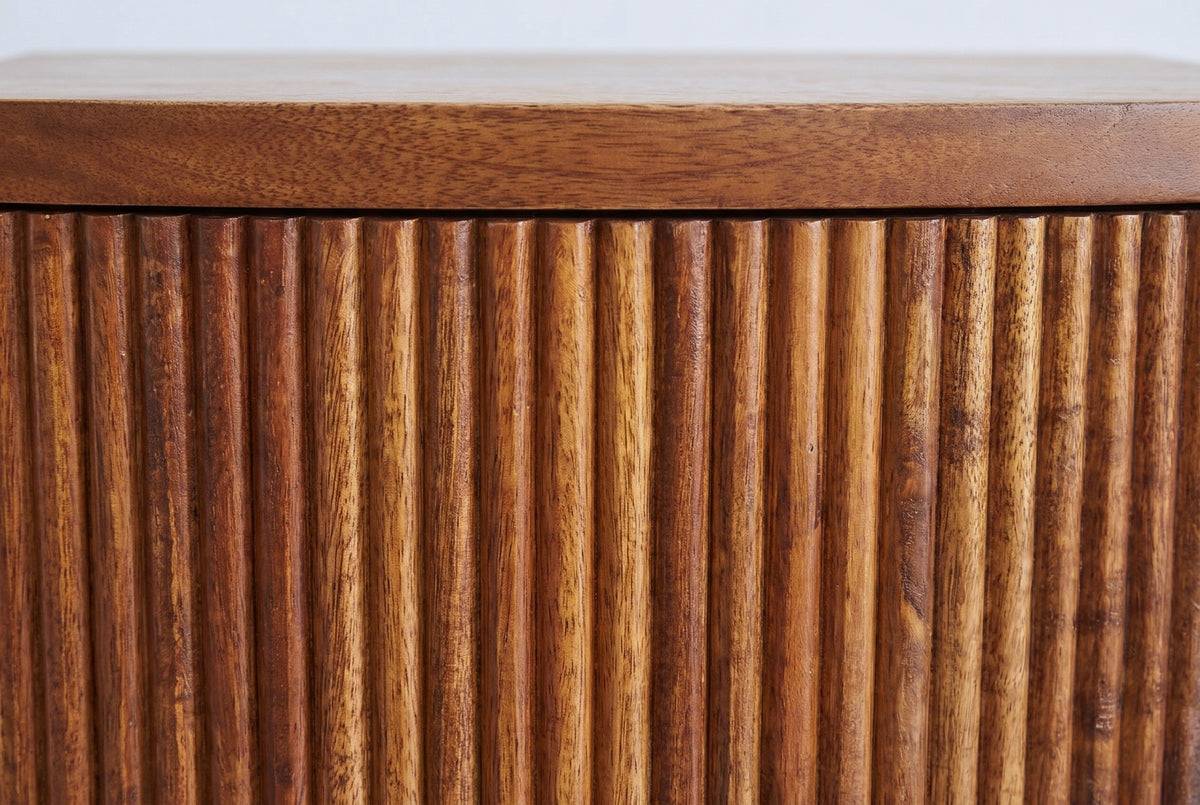 Close-up of the reeded mocha mango wood on the Gavoi nightstand: vertical rounded reeds below the plain mango top