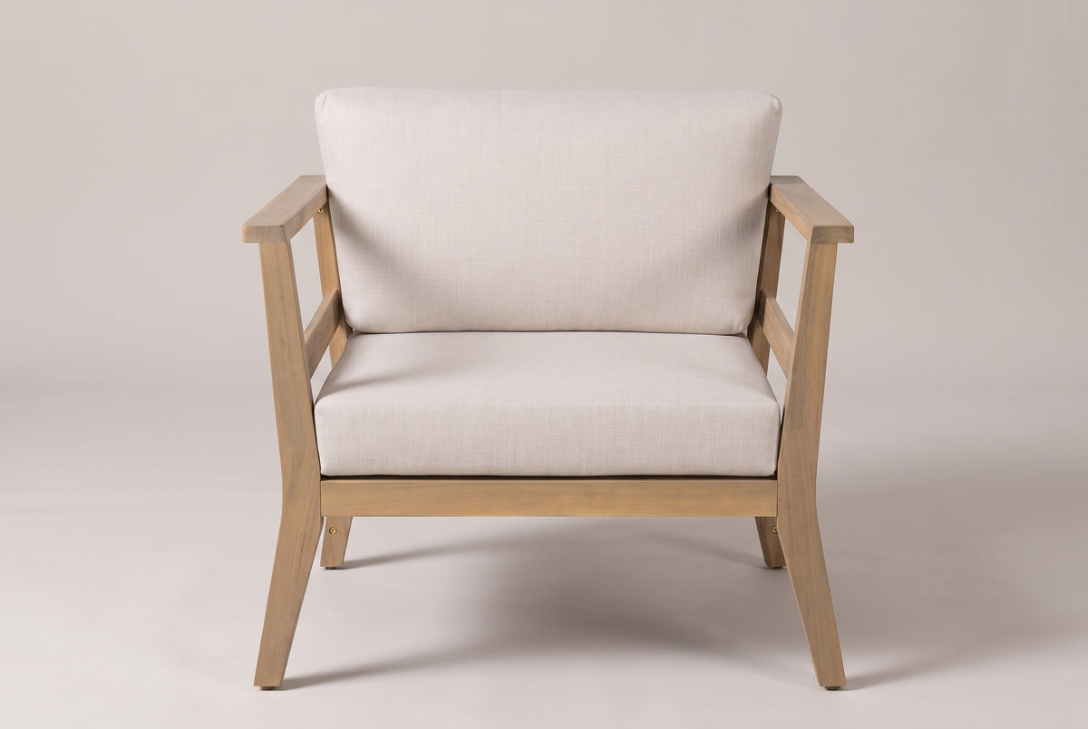 The Geraci club chair seen straight from the front: flat arms, the front rail under the seat cushion and four slightly splayed legs