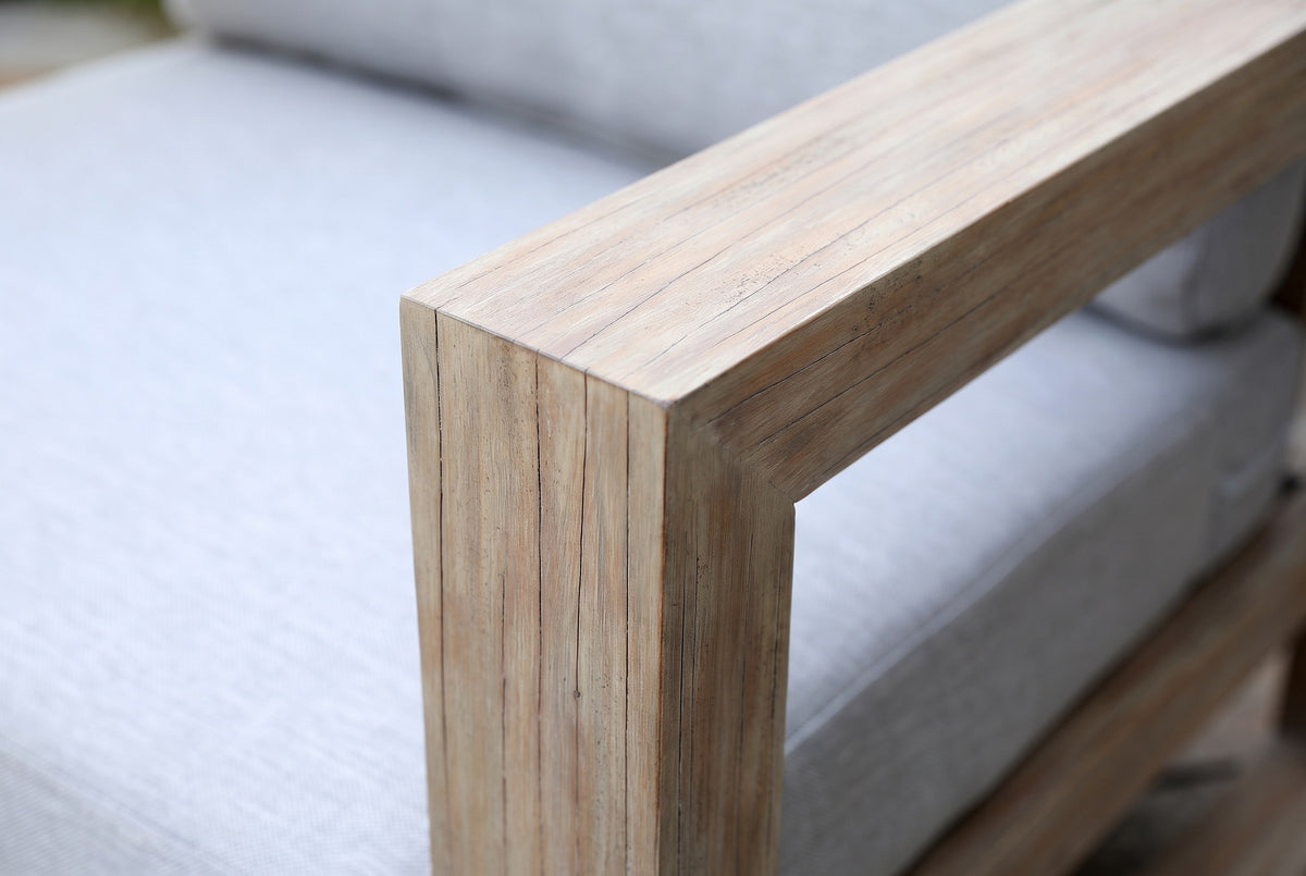Close-up of the eucalyptus on the Giardini chair: the square corner where the flat arm meets the front post, beside the light gray seat cushion