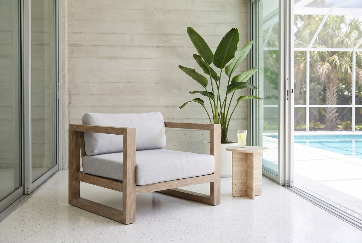 Giardini eucalyptus lounge chair on a white terrazzo lanai in Sarasota, a board-formed concrete wall, a bird of paradise and the pool behind (side table not included)