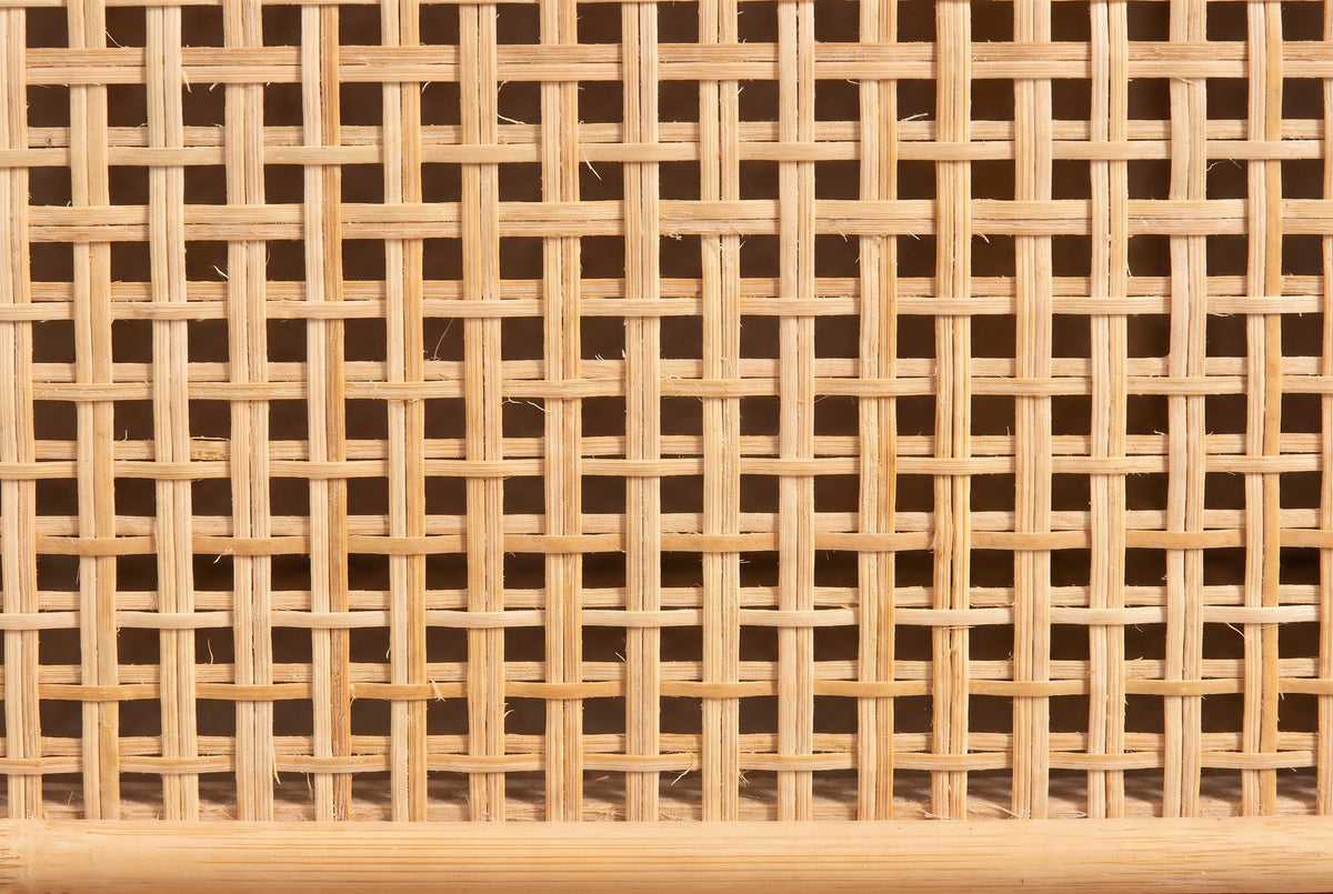 Close-up of the woven cane on the Giovinazzo sideboard: flat natural strands woven over and under in an open square mesh, with a round rattan pole along the bottom edge