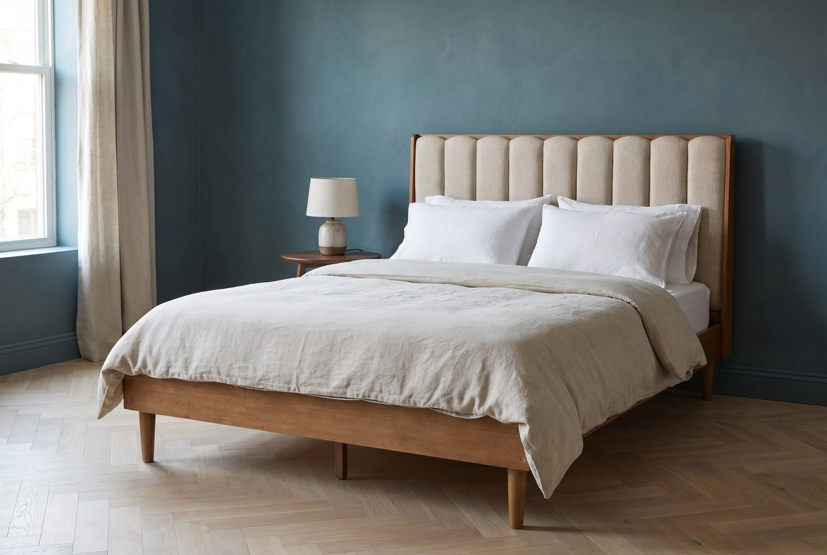 Giulianova bed against a deep teal-blue plaster wall in a Brooklyn brownstone bedroom with a herringbone oak floor