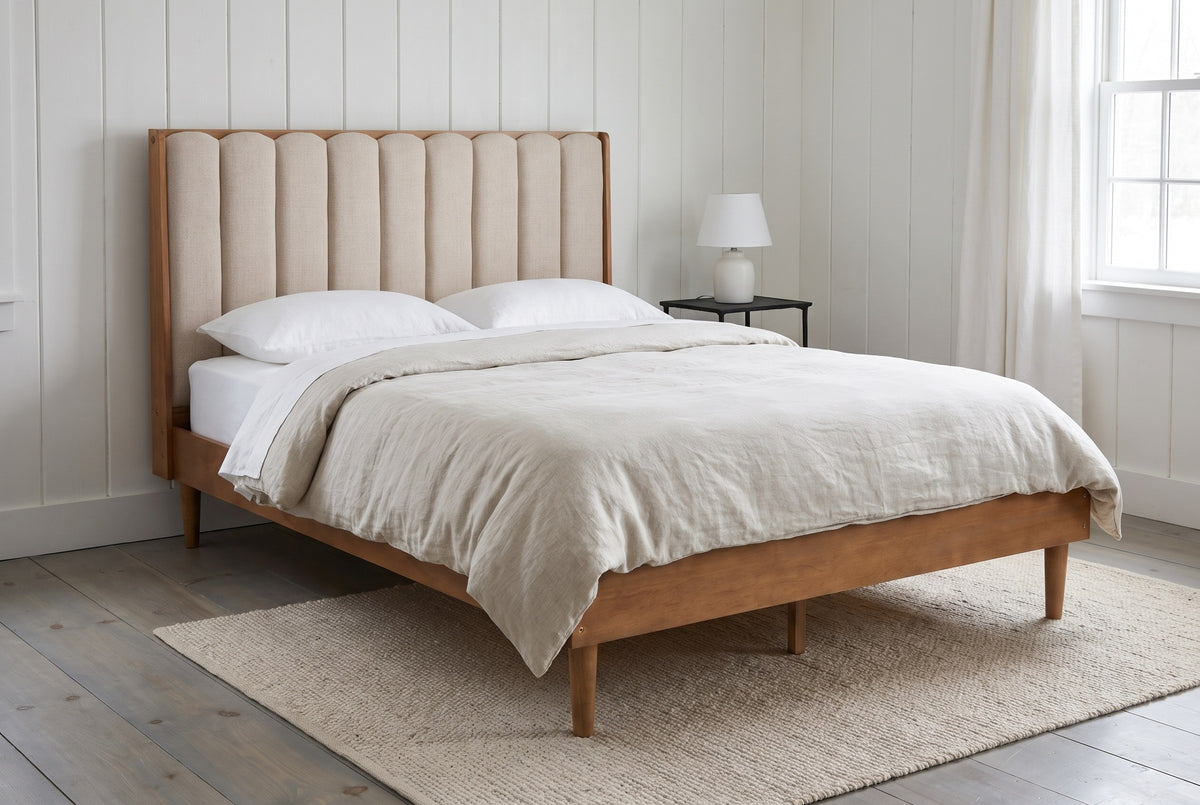 Giulianova bed against white painted vertical boards in a Vermont farmhouse bedroom with a grey-washed pine floor