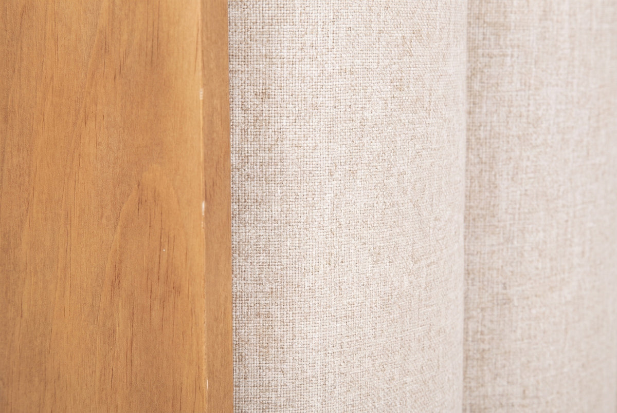 Close-up of the Giulianova bed where the wheat pine frame meets the oatmeal woven fabric of two padded channels