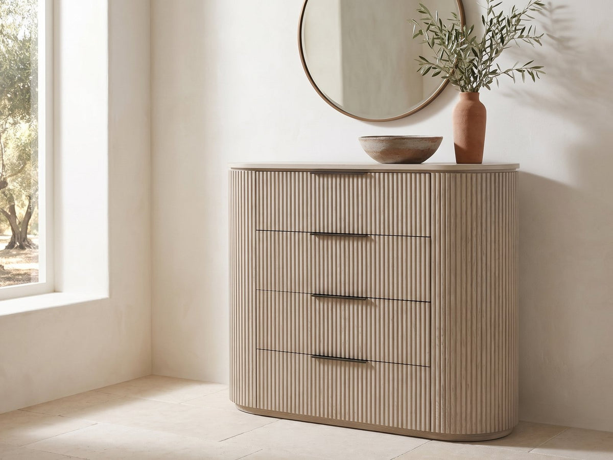Gradisca 50-Inch Light Oak 4-Drawer Chest under a round bronze mirror in a villa bedroom