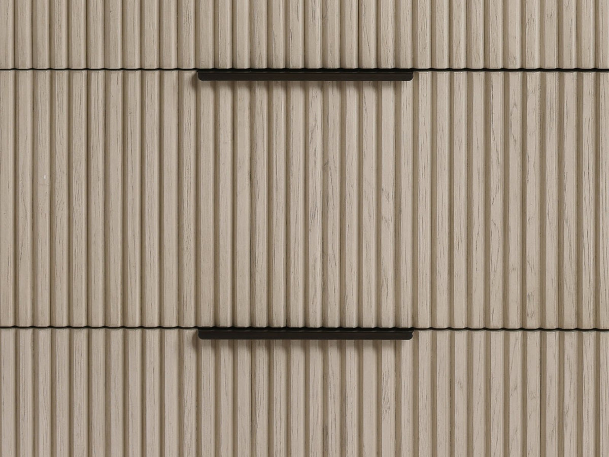 Close-up of the Gradisca 50-Inch Light Oak 4-Drawer Chest: the vertical oak reeds of the drawer fronts and the slim bronze edge pulls
