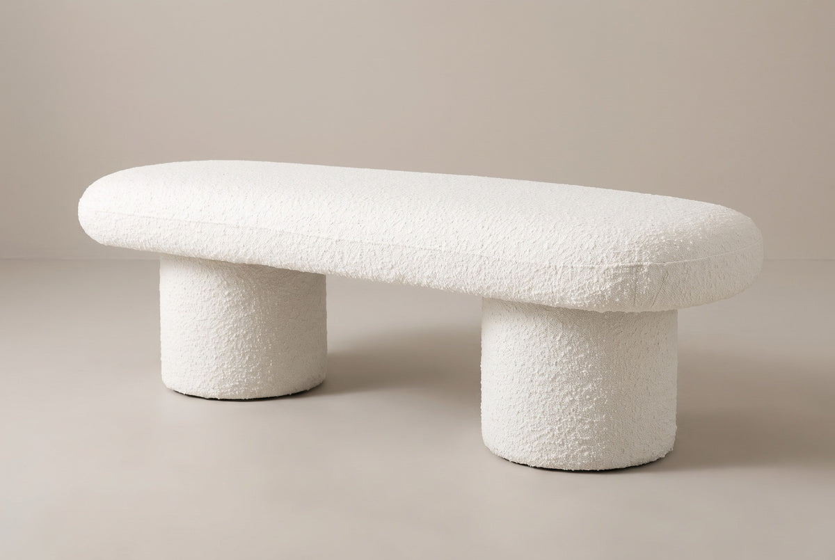 The Gubbio bench in ivory boucle, three-quarter view on a light studio backdrop