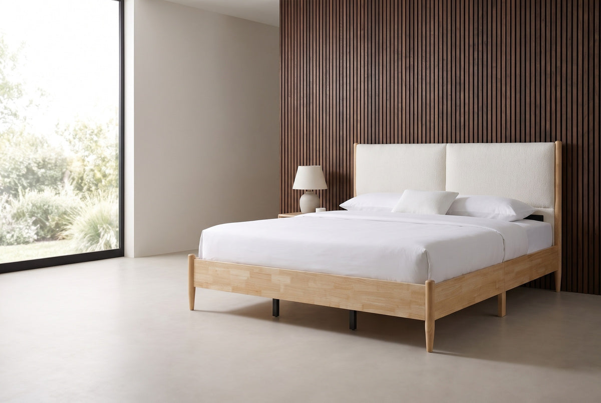 Isernia natural rubberwood bed with two cream headboard cushions against a walnut slat wall in a Los Angeles bedroom, a floor-to-ceiling window at the left