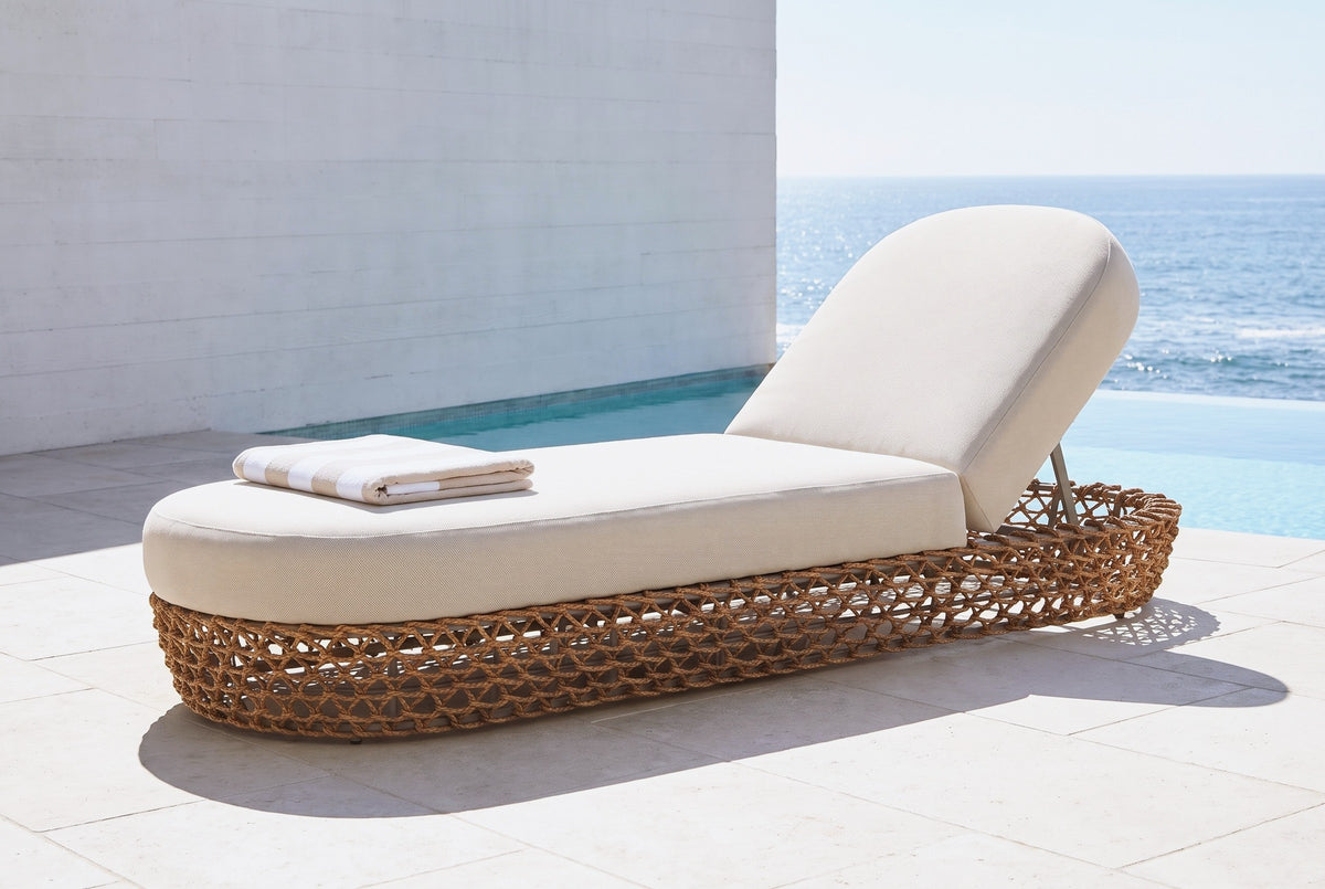 Isnello woven lounger on pale limestone beside an infinity pool at a La Jolla house, a white concrete wall and the Pacific behind (towel not included)