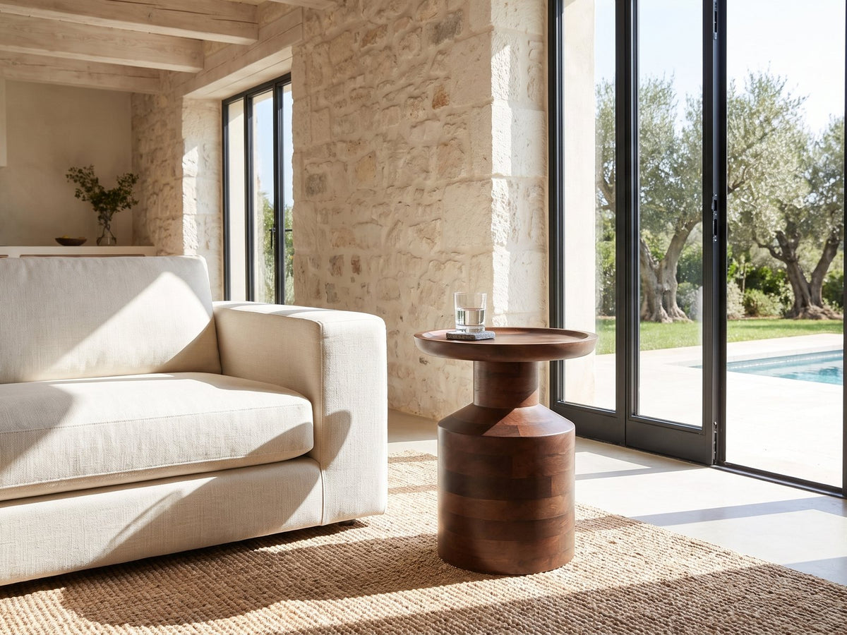 Lagonegro Solid Mango Pedestal Side Table beside a linen sofa in a poolside villa
