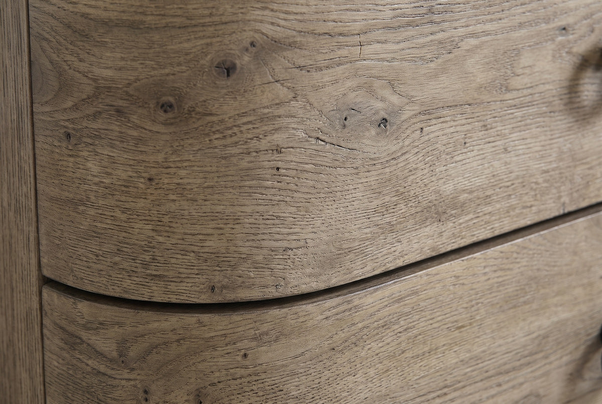 Close-up of the Lanusei nightstand: weathered English knotty oak veneer with small knots, open pores and a wavy grain, and the thin shadow line between two drawer fronts