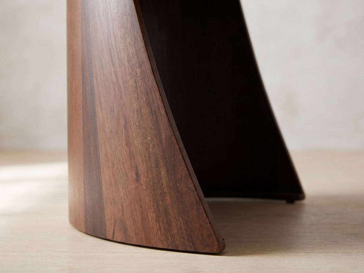 Close-up of the Laurenzana Dark Brown Mango Nesting Side Tables, Set of 2: the curved mango shell of the large table sweeping down to the floor