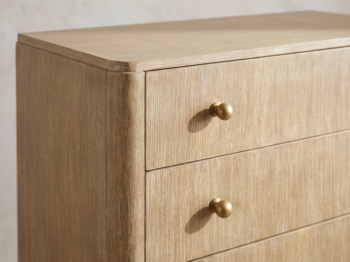 Close-up of the Lazise 38-Inch Sand Wash 5-Drawer Chest: round aged-brass knobs on the wire-brushed sand wash drawer fronts