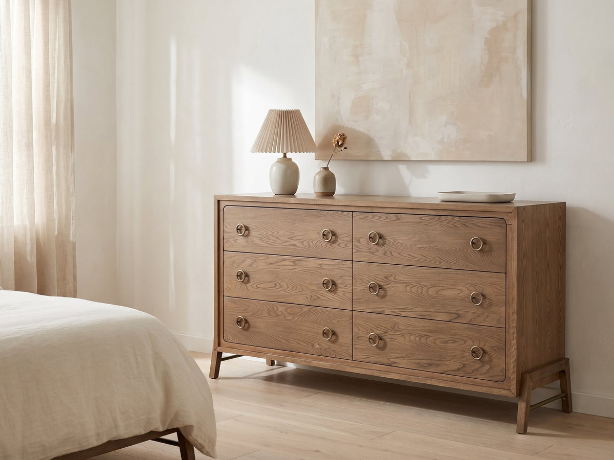 Lendinara 66-Inch Latte Elm 6-Drawer Dresser against a plaster wall under an abstract canvas in a bright bedroom