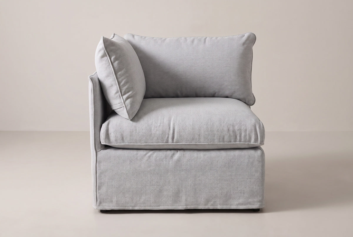 The Lentini corner chair seen from the front: the back panel behind the seat, the side panel on the left and the right side open