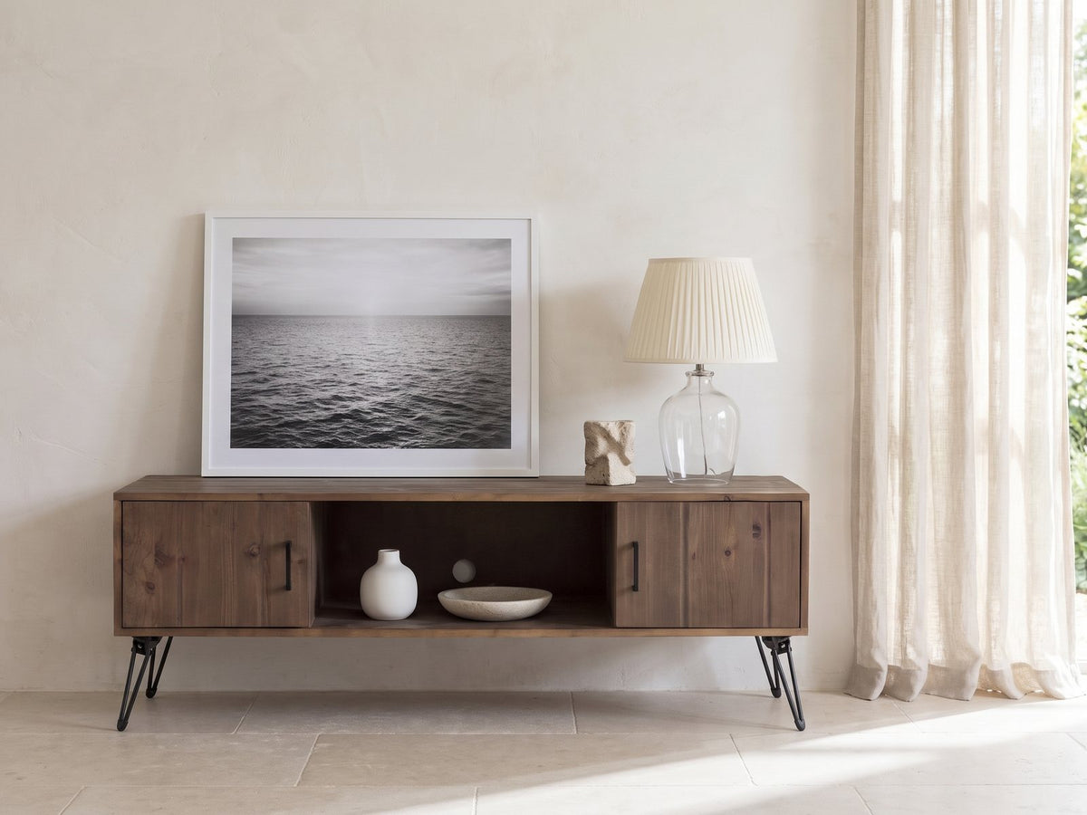 Lerici 60-Inch Reclaimed Wood Hairpin Leg Media Console styled with a leaning print, a lamp and ceramics in a bright plaster room