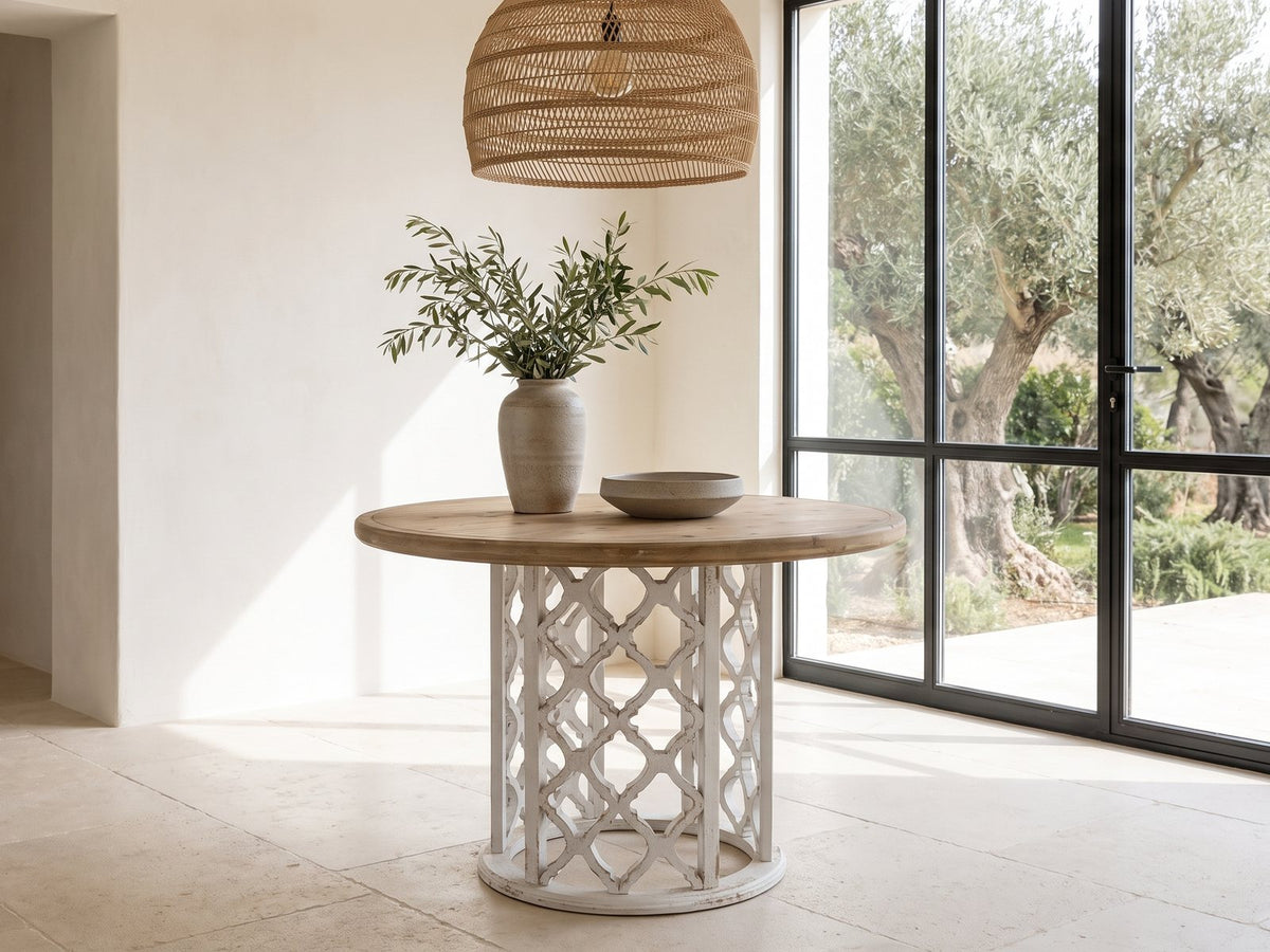 Locri 47-Inch Round Fir Lattice Pedestal Dining Table in a sunlit villa dining area with olive trees outside