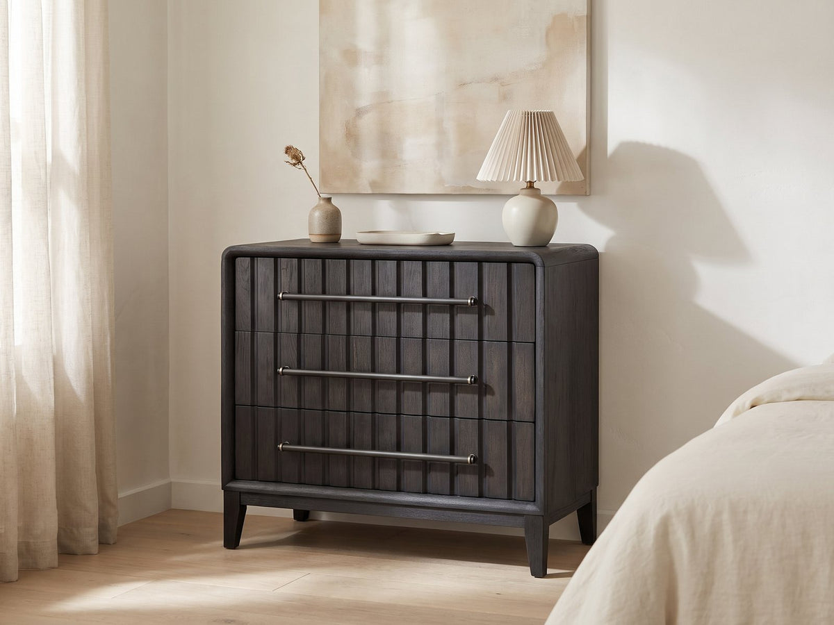 Lonigo 38-Inch Peppercorn 3-Drawer Chest against a plaster wall under an abstract canvas in a bright bedroom